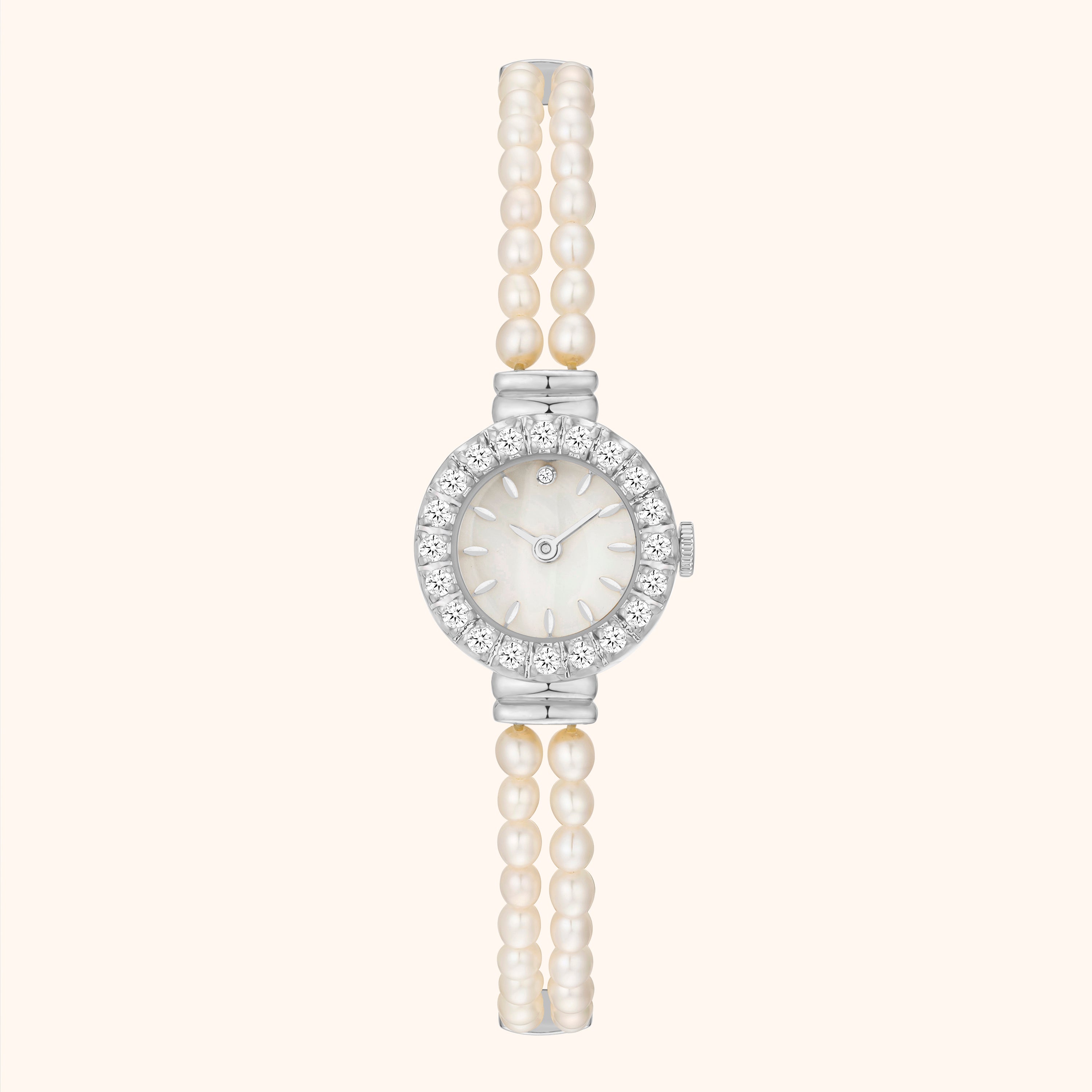 Orologio con cinturino in perle e cassa in argento su sfondo bianco