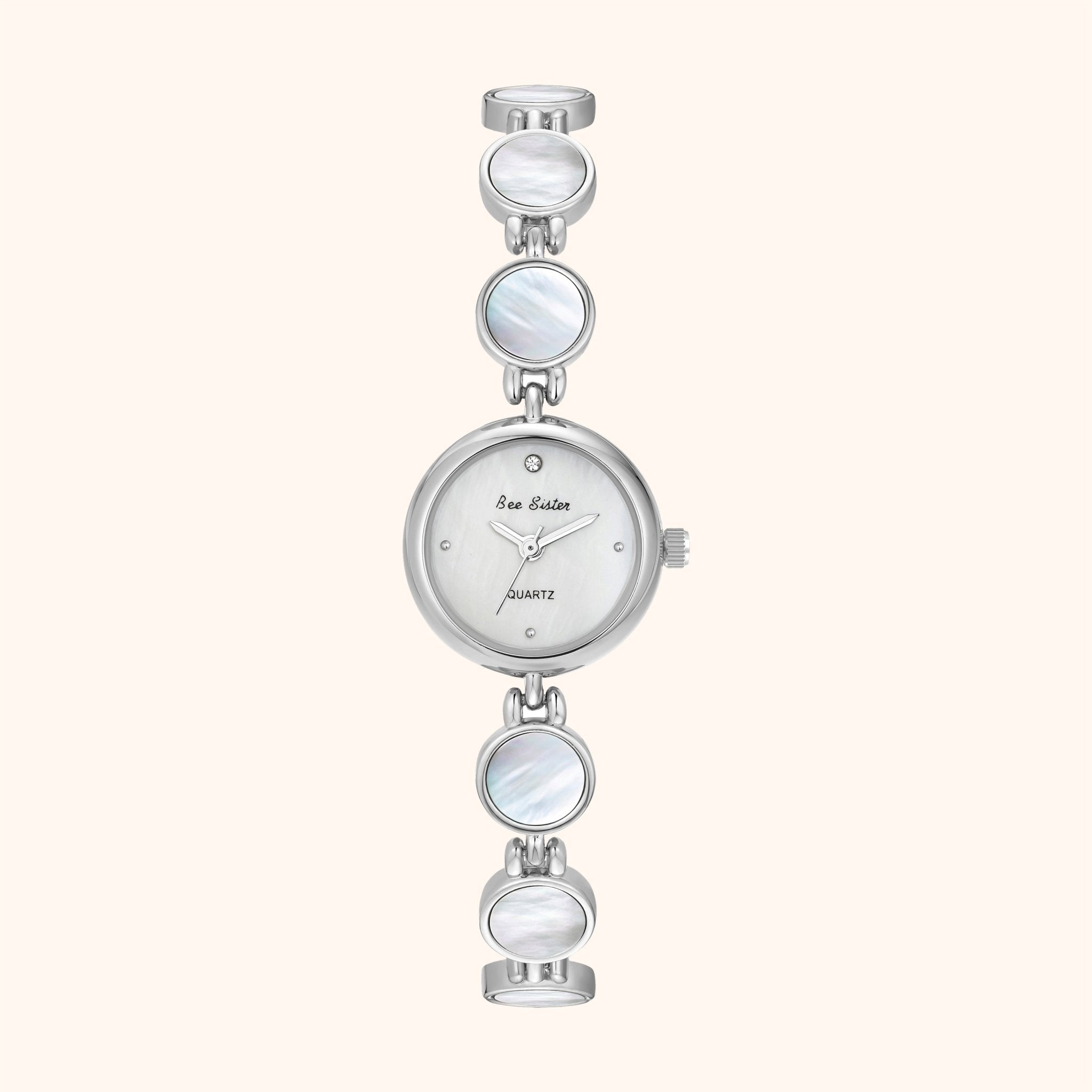 Montre argentée d'inspiration vintage avec trois éléments de cadran circulaires sur fond blanc